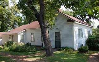 A multi-room, wooden home painted white. This home is representative of 1940s middle class families in Springdale. 