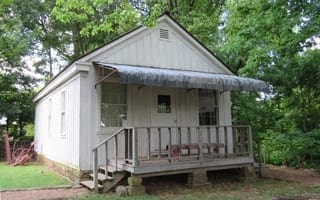 A small white building with stairs in front. This is Steele General Store, which dates to the 1870s. 