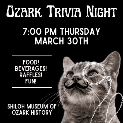 Photograph of the head and neck of a gray tabby cat with an illustrated monocle with chain over its left eye and an illustrated handlebar mustache under its nose. It looks up to white text with black background that reads, "Ozark Trivia Night, 7:00 PM Thursday, March 30th. Food! Beverages! Raffles! Fun! Shiloh Museum of Ozark History."