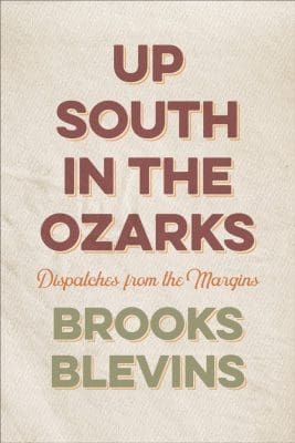 Book with a beige cover. The upper half has the words, in maroon capital letters, that read “Up South in the Ozarks.” Beneath it are the words, in orange cursive lettering, “Dispatches from the Margins.” Below it, in all capital letters in light avocado coloring, “Brooks Blevins.”