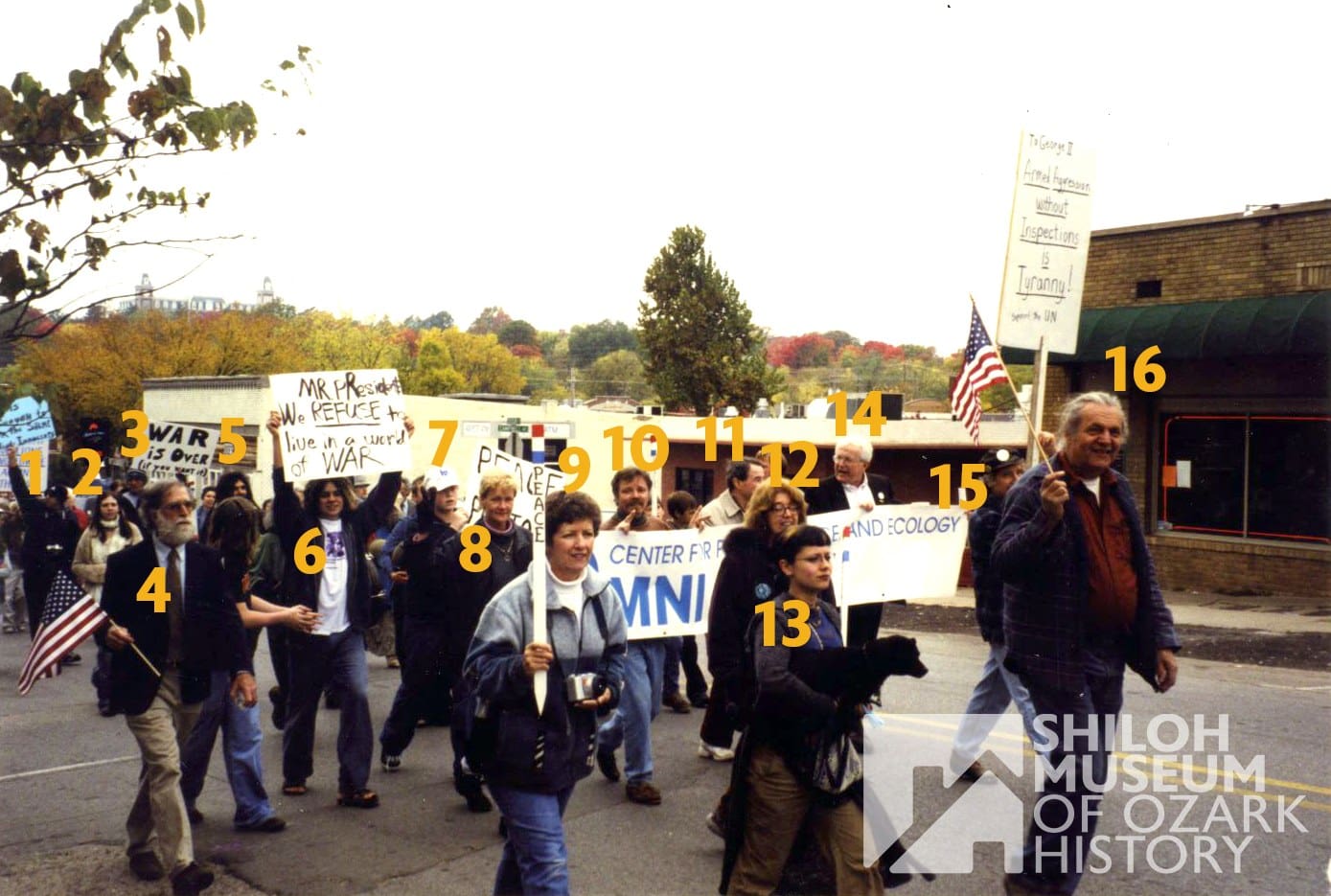 It’s #PhotoIDFriday! 📸🚩

Can you help us solve a local history mystery from the early 2000s? We are looking for identifications for this group of anti-war protesters captured on October 26, 2002.

The photo looks to have been taken right on Dickson Street in Fayetteville. While we think we recognize one or two faces in the crowd, we want to make sure we get it right! Can you help us identify the people in this image, or perhaps the exact buildings and storefronts behind them?

If you recognize a face, a place, or remember this day, please let us know in the comments!

📢 Note: If you share this post to your own page, please tag the Shiloh Museum of Ozark History so we can see your responses and save this valuable info for our archives!

Have a safe and wonderful Memorial Day Weekend! ✨

Photo from the Shiloh Museum’s Cyrus Dean Young Collection (S-2003-152-3854).

#ShilohMuseum #FayettevilleAR #DicksonStreet #WashingtonCountyAR